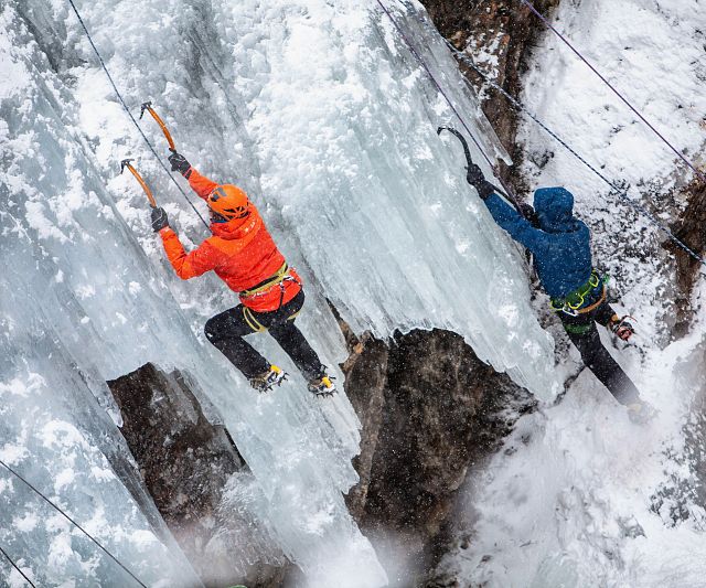 Ice climbers in Pitztal climb high above the Eisfall-Eis Total icefall, ice climbing festival
