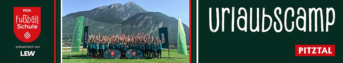 Eine Gruppe Jugendlicher in grünen Trikots posiert auf einem Rasen vor einer Bergkulisse. Sie heben die Hände. Neben ihnen wehen zwei grüne Fahnen im Wind.