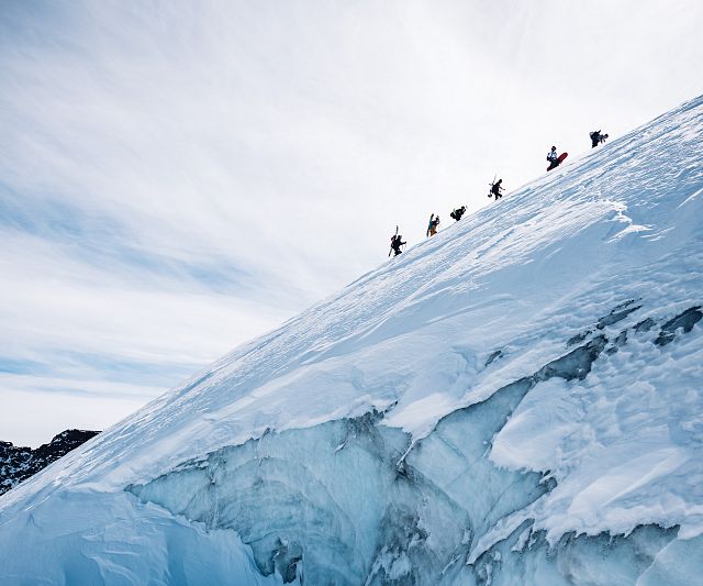 Tourengeher am Grad Richtung Gipfel mit Eiswand im Vordergrund