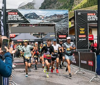 Bei strahlendem Wetter beginnt das Young Talents Race des Pitz Alpine Glacier Trails. Junge Läuferinnen und Läufer sprinten voller Energie über die Startlinie.