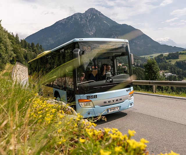 Der öffentliche Bus bei Arzl mit dem Berggipfel Tschirgant im Hintergrund