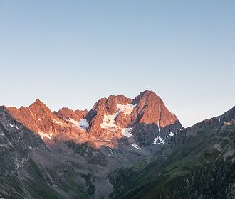 Die Watzseespitze am Kaunergrat bei Sonnenaufgang mit Alpenglühen