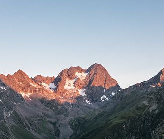 Die Watzseespitze am Kaunergrat bei Sonnenaufgang mit Alpenglühen