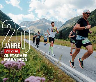Eine Gruppe von Läufern joggt auf einer Straße durch ein malerisches Tal, umgeben von Bergen. Am Bildrand steht: "20 Jahre Pitztal Gletscher Marathon".