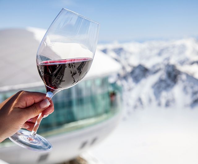 Weinglas mit Café 3440 im Hintergrund