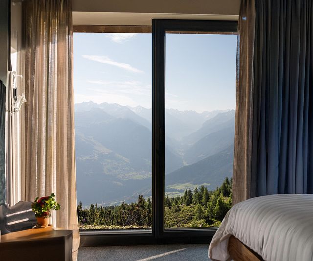 Hotelzimmer von innen mit einem sommerlichen Ausblick auf die Berge