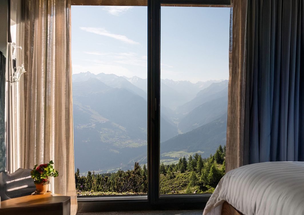 Hotelzimmer von innen mit einem sommerlichen Ausblick auf die Berge