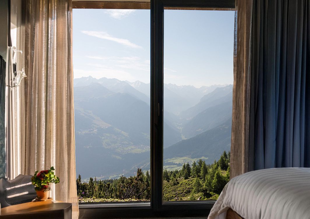 Hotelzimmer von innen mit einem sommerlichen Ausblick auf die Berge
