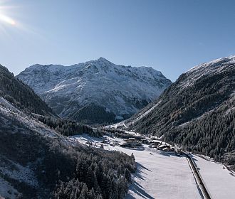 Das Bergdorf Tieflehn im Winter in der Gemeinde St. Leonhard mit dem Berggipfel Mittagskogel im Hintergrund