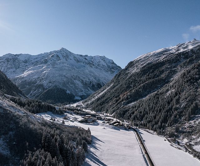 Das Bergdorf Tieflehn im Winter in der Gemeinde St. Leonhard mit dem Berggipfel Mittagskogel im Hintergrund
