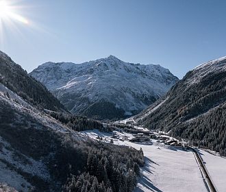 Das Bergdorf Tieflehn im Winter in der Gemeinde St. Leonhard mit dem Berggipfel Mittagskogel im Hintergrund