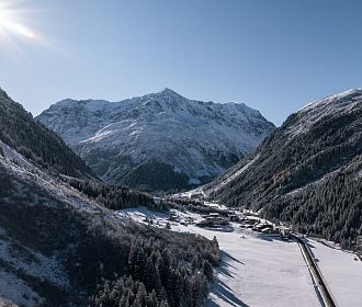 Das Bergdorf Tieflehn im Winter in der Gemeinde St. Leonhard mit dem Berggipfel Mittagskogel im Hintergrund